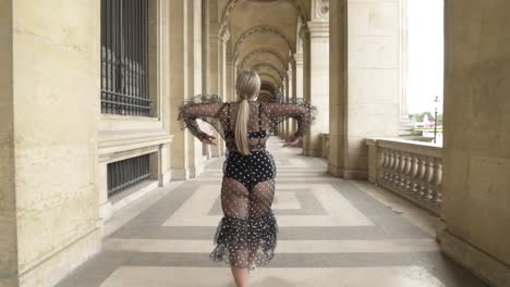 stylish woman in polka dot dress in parisian arcade