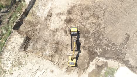 vista superior de la excavadora y los camiones en el sitio de construcción