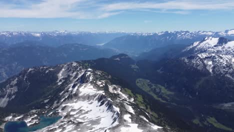 Snow-Mountains-with-Tree-Filled-Valleys-and-Crystal-Clear-Lakes---Drone-Pan-4K-UHD