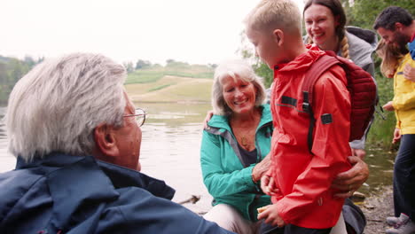 Multi-generation-family-spending-time-together-by-a-lake-in-the-countryside,-close-up,-Lake-District,-UK