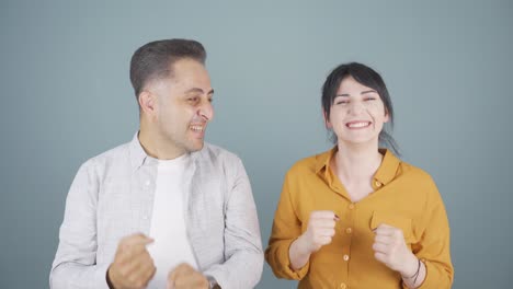 una pareja regocijándose mirando a la cámara.