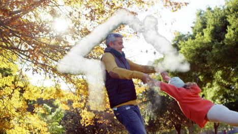 humo formando una forma de casa contra el padre caucásico jugando con su hija en el parque