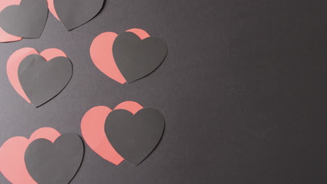 video de formas de corazón de papel rojo y negro en fondo negro con espacio de copia