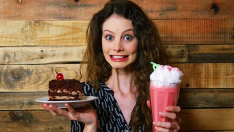 Portrait-of-female-customer-holding-plate-with-pastry-and-icecream-float