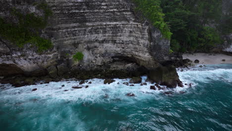 ocean waves crashing on rocky cliffs of nusa penida, bali in indonesia