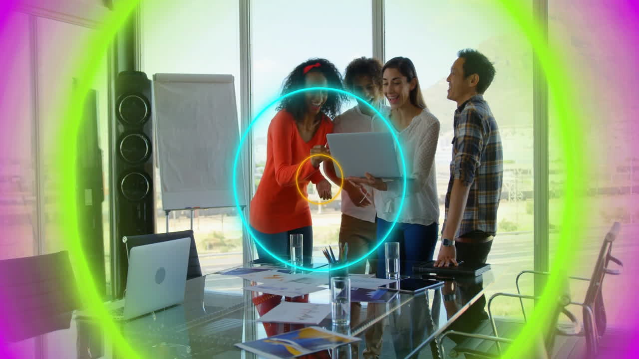 Diverse group collaborating with laptop over colorful circular animation in office