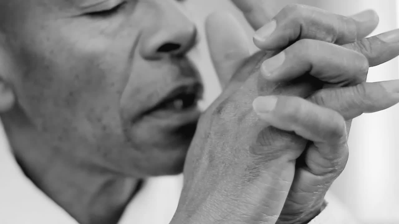 hombre orando a dios hombre caribeño orando con las manos junto con la gente en fondo gris negro stock video stock footage