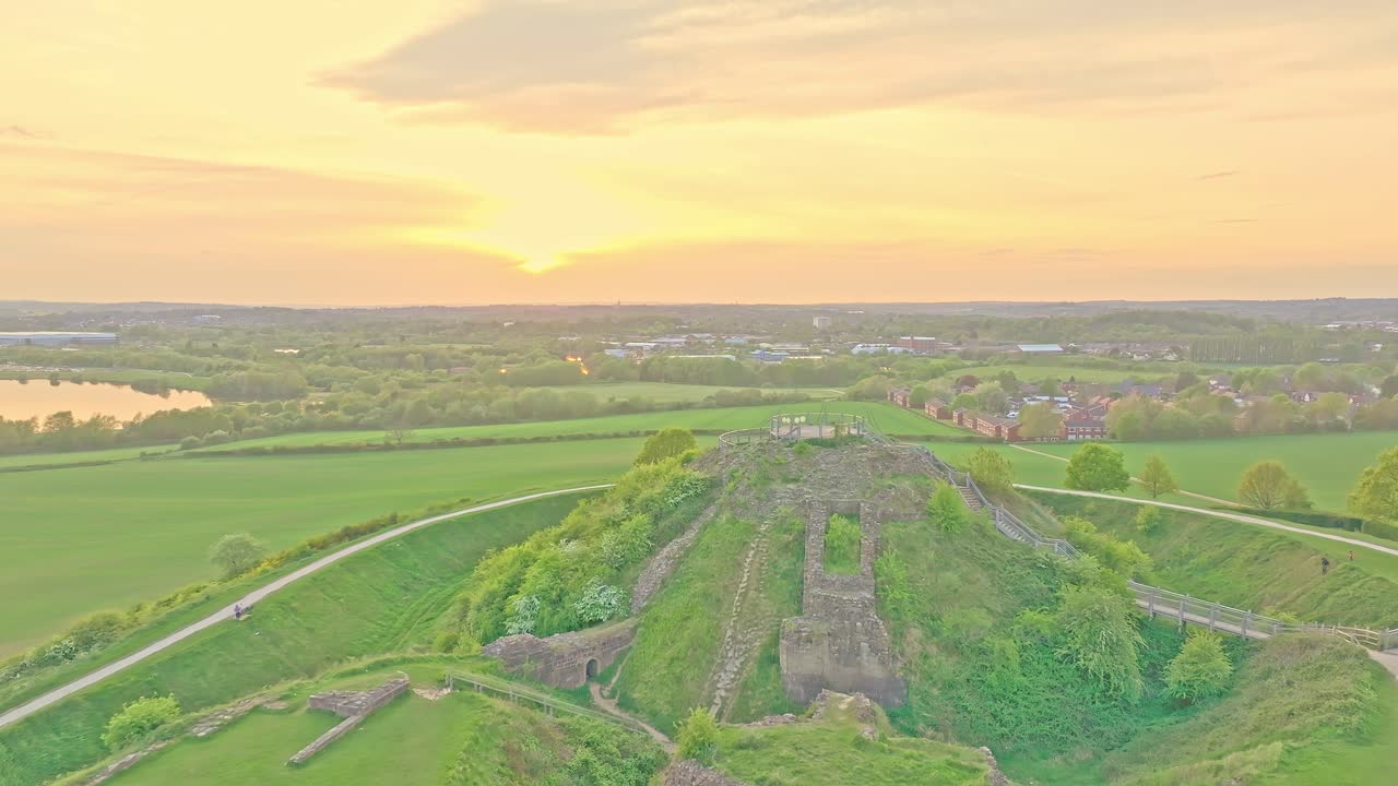 Wide aerial of historic hilltop ruin and circular earthworks in open countryside, Sandal Castle Wakefield UK