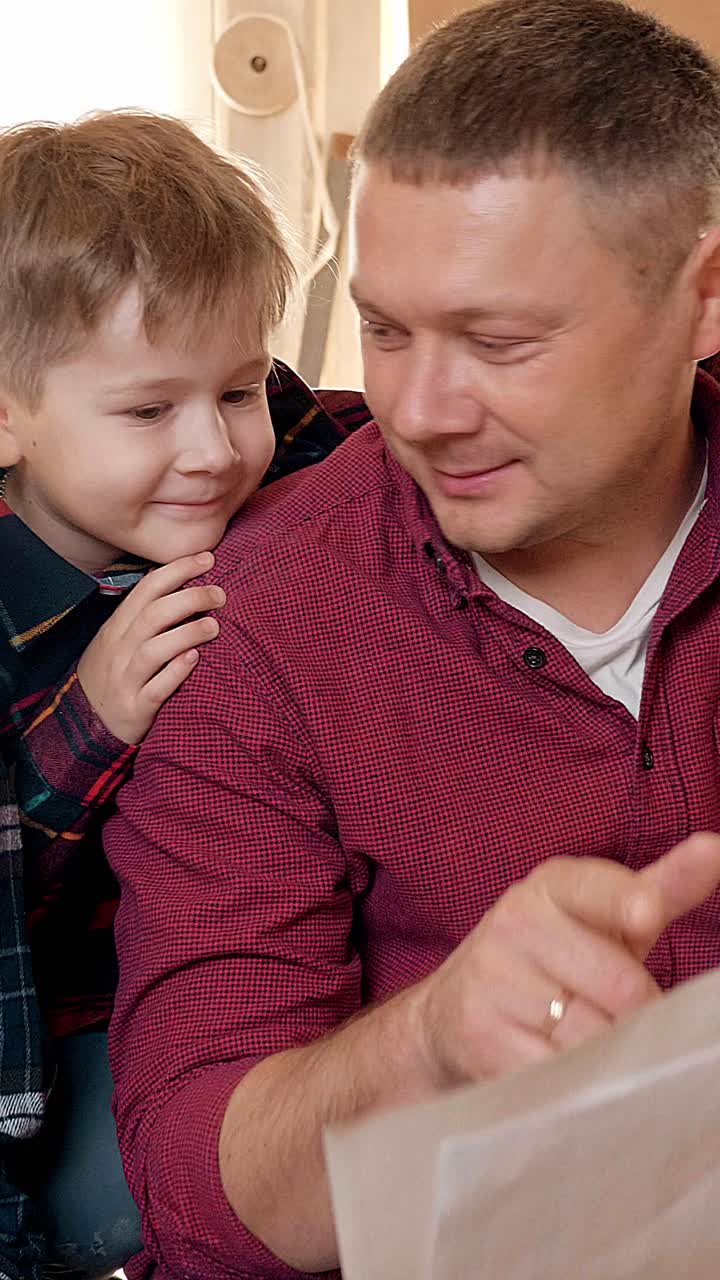 Father and son engaged in reading together, showcasing a moment of connection and learning in a cozy indoor environment with warm lighting