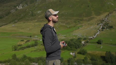 Filmmaker-drone-pilot-takes-off-drone-from-hand-in-mountain-scenery,-static