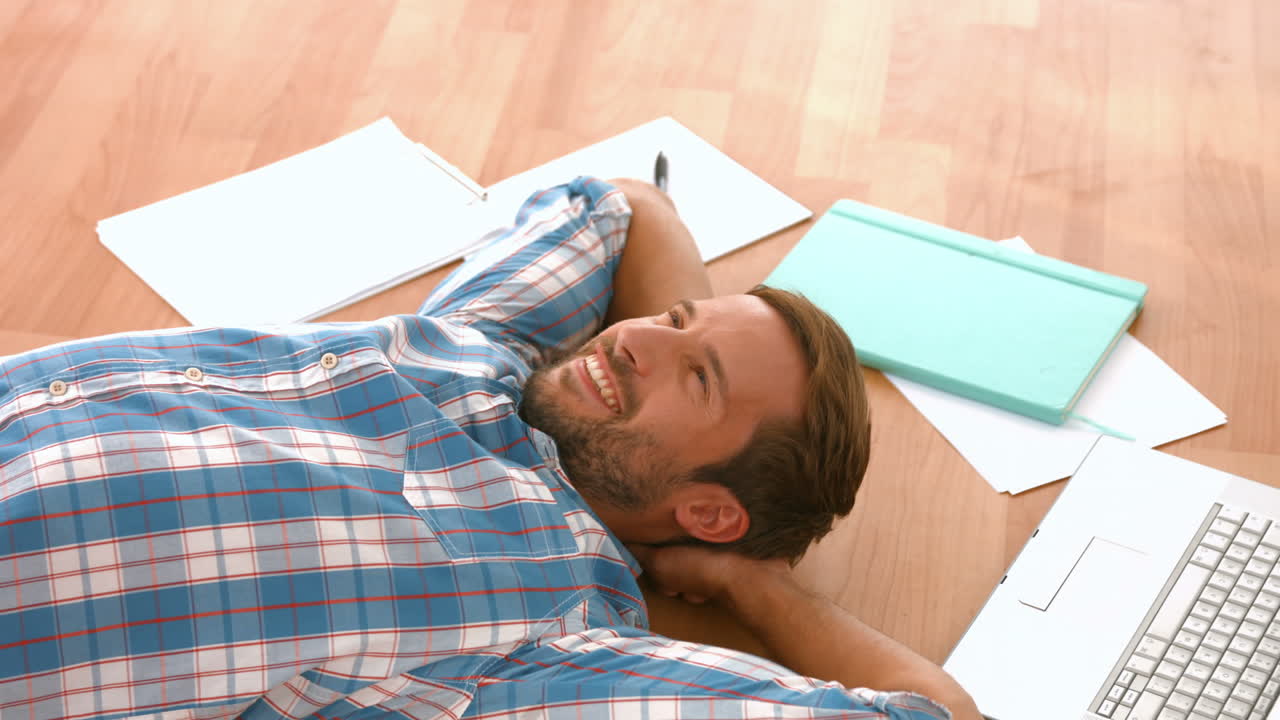 Uomo felice e bello sdraiato sul pavimento