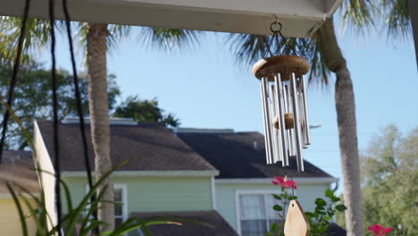 calming and relaxing view from a garden with wind chimes during summer with palm trees and cute houses in tropical florida