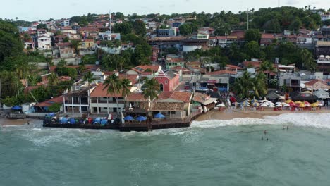 dolly salió girando una toma de avión no tripulado de la hermosa capilla rosa de san sebastián en la famosa ciudad de playa turística tropical de pipa, brasil en río grande do norte en una cálida noche soleada de verano