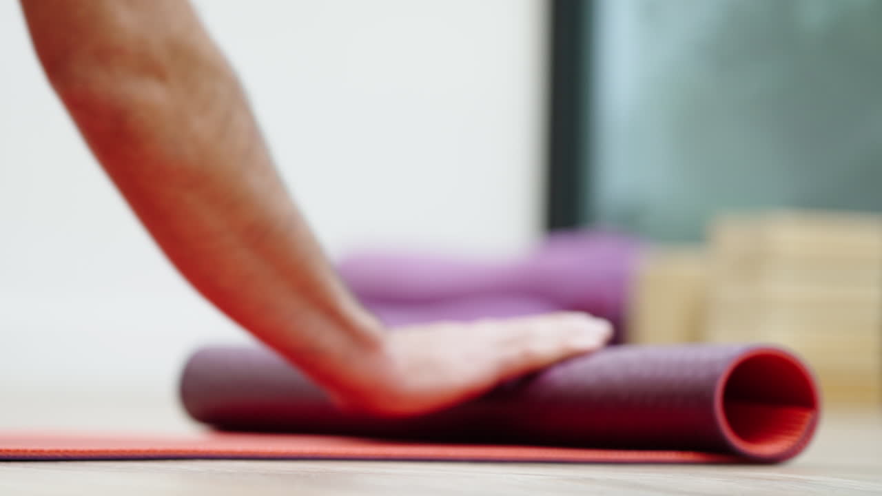 Close-up of Hands Unrolling Yoga Mat Before Workout