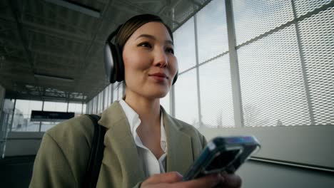 mujer usando un teléfono inteligente en la estación de tren