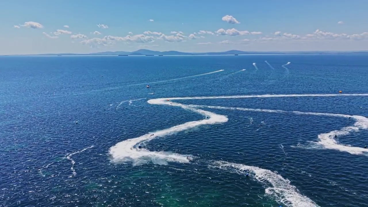 青空の下、透明な海面を高速で疾走するジェットスキー