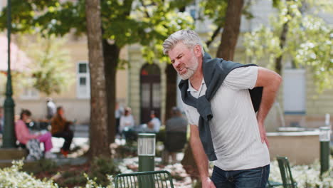 mature man suffers from back pain in lower part of spine unbearable spasm torn muscles pinched nerve