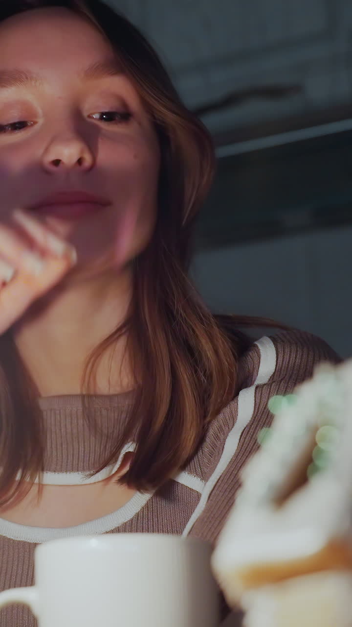 정교하게 장식 된 생강 집 에 불타는 은 불의 클로즈업, 여자가 따뜻한 음료를 즐기고, 어두운 밤 설정에서 부드러운 불처럼 컵을 부드럽게 낮추고