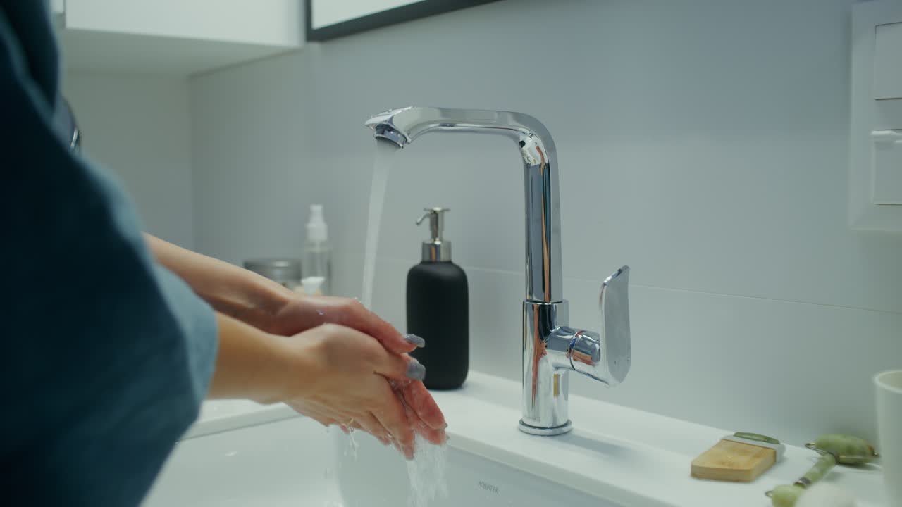 Donna che si lava le mani in un bagno moderno