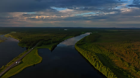 AERIAL-RV-driving-in-middle-of-lakes-and-polar-nature,-dramatic-evening-in-Lapland