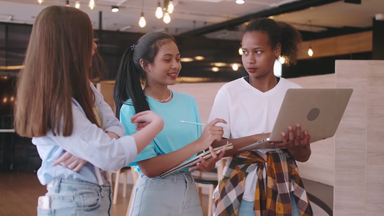 A group of friends discussing homework in a coffee shop. Multiethnic students having fun chatting in school.