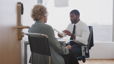 senior woman meeting with male financial advisor in office