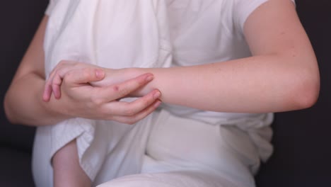 a woman rubbing a spot on her skin to relieve an itch - close up