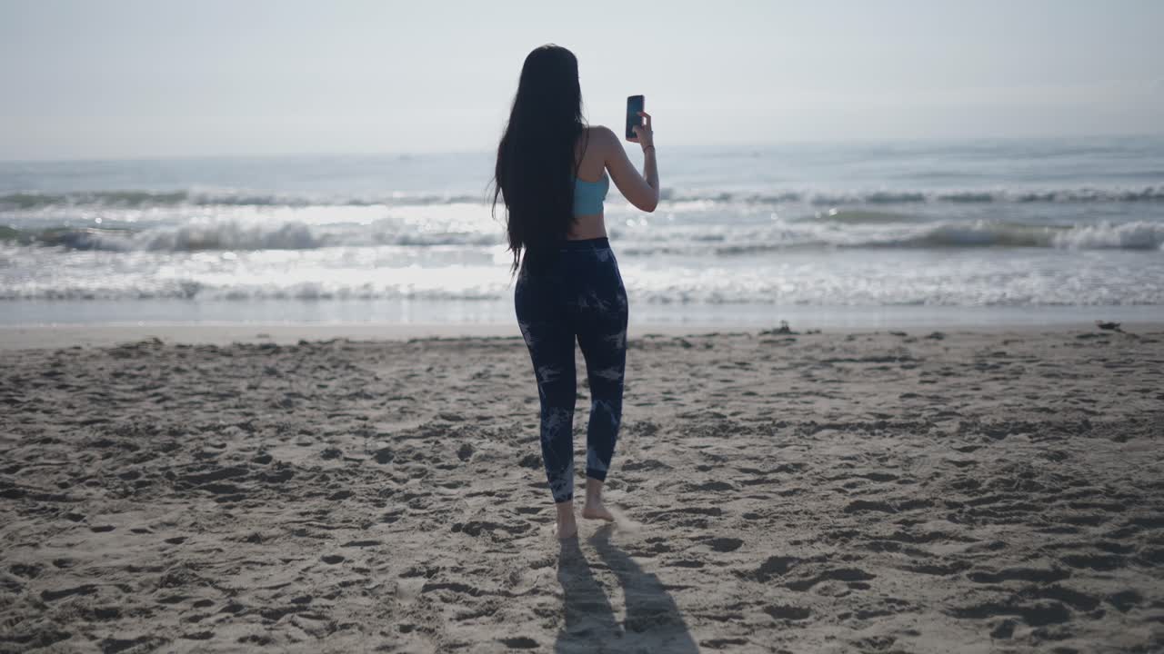 해변에서 셀피를 찍는 여자