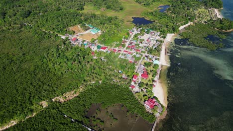 scenic aerial overview of lush village town along tropical island coastline at yocti, san andres, catanduanes, philippines.