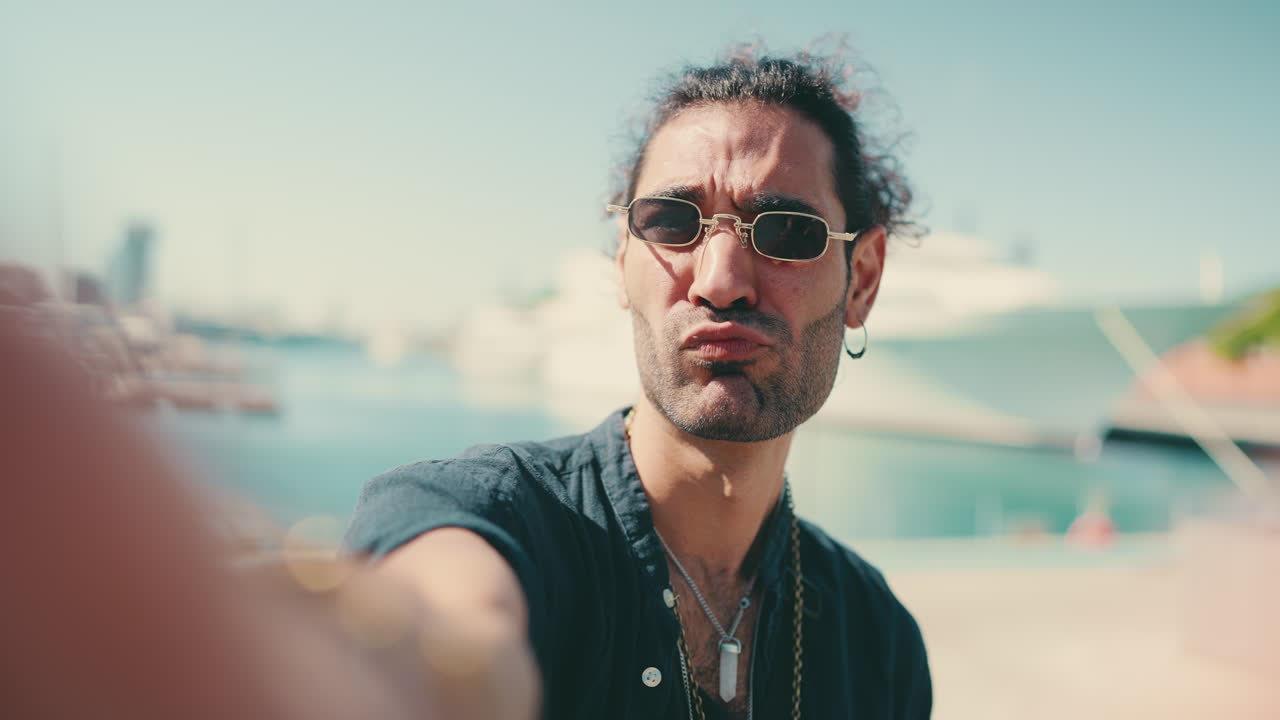 Uomo che si scatta un selfie su un molo con una nave da crociera sullo sfondo