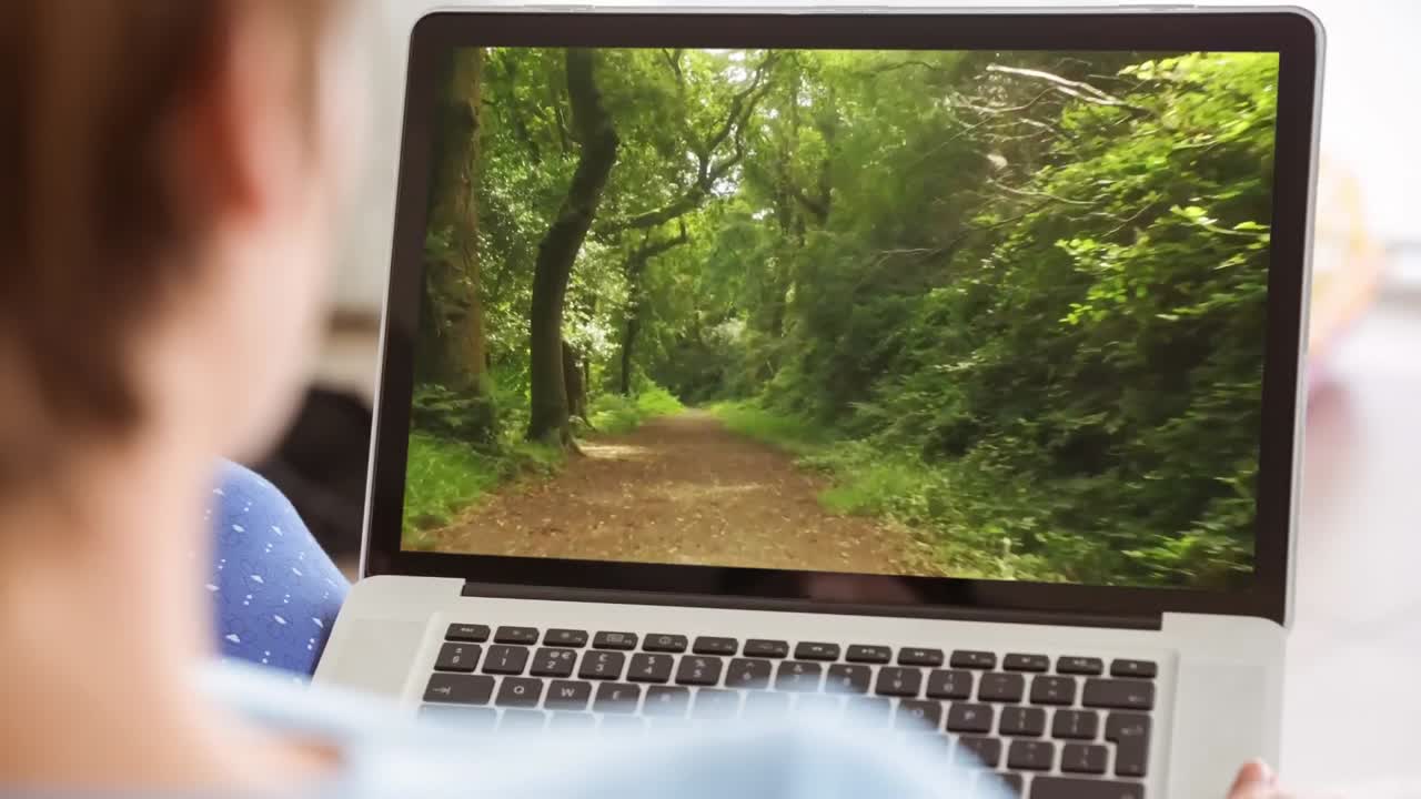 mujer usando computadora portátil con camino en el bosque 4k