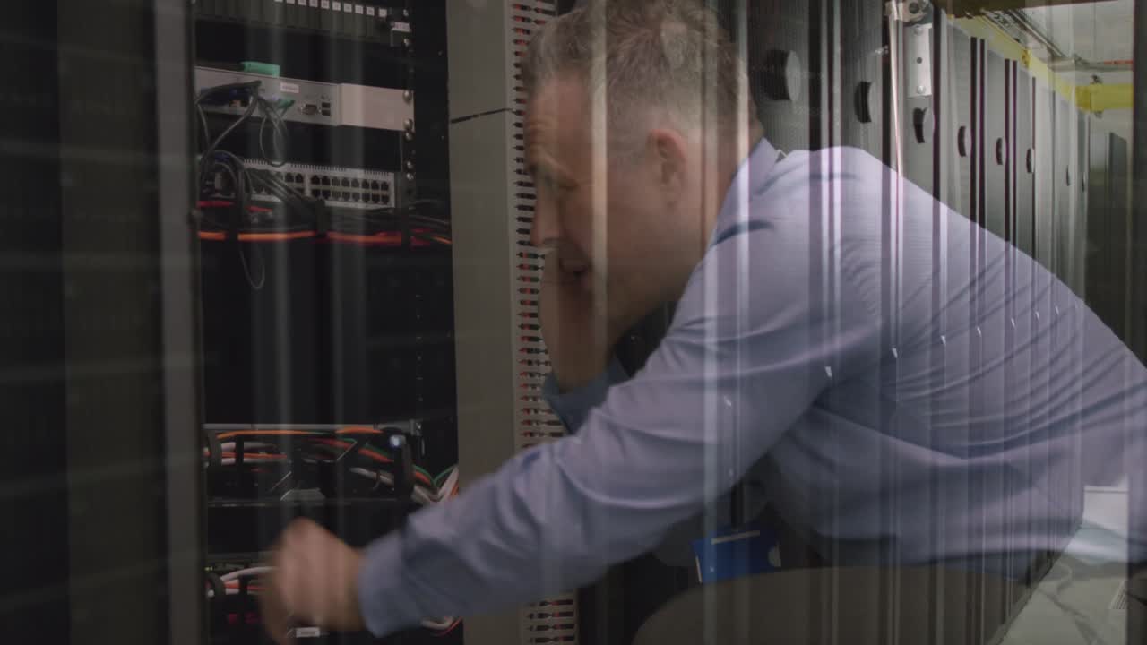 Caucasian senior male engineer talking on smartphone while working in computer server room