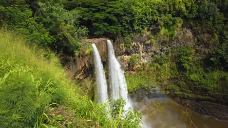 4k hawaii kauai static of wailua falls with tall grass in foreground