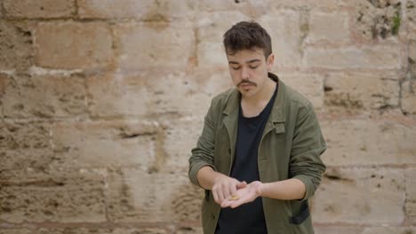 man dancing in front of a stone wall