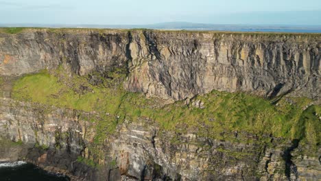 Aerial-shot-of-the-Cliffs-of-Moher-in-Ireland,-showcasing-the-rugged-coastal-beauty-and-natural-geological-formations