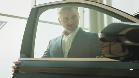 man checking out a car in a showroom