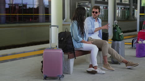 pareja esperando en la estación de tren