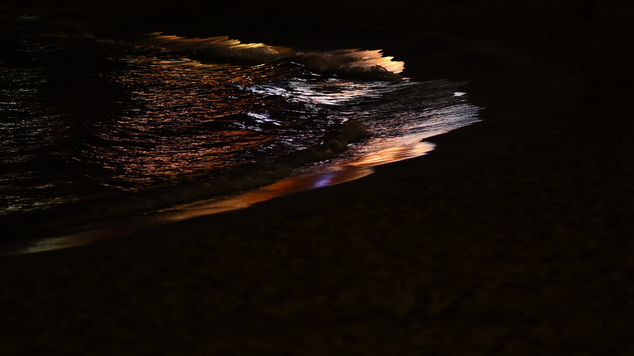 Sea waves at night with reflections in Cannes, France