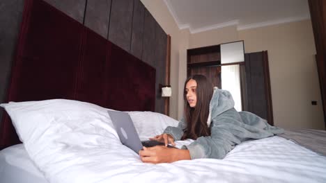 mujer trabajando en la computadora portátil en la cama
