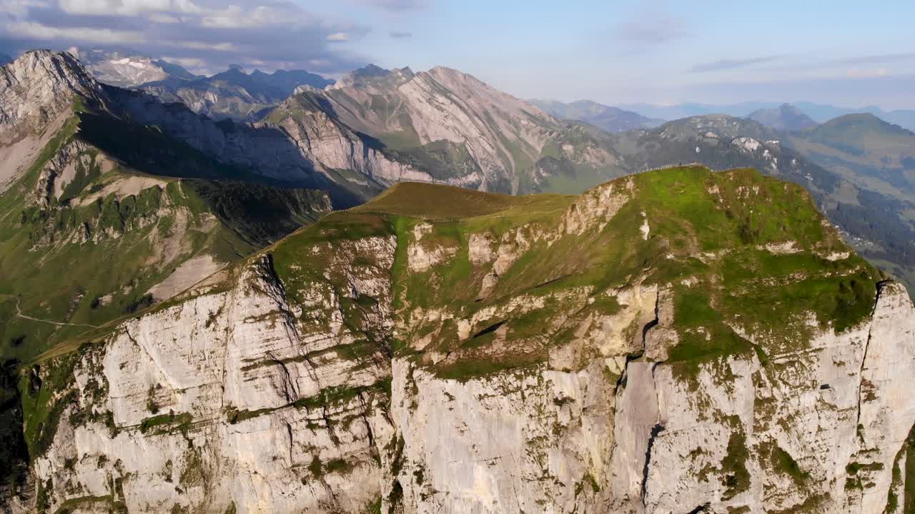 vista aérea de niederbauen chulm en una mañana dorada de verano en los alpes suizos con una vista giratoria desde los acantilados del pico hacia los fiordos del lago lucerna, uri, mitos y el sol naciente
