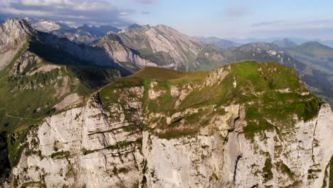 Vista-Aérea-De-Niederbauen-Chulm-En-Una-Mañana-Dorada-De-Verano-En-Los-Alpes-Suizos-Con-Una-Vista-Giratoria-Desde-Los-Acantilados-Del-Pico-Hacia-Los-Fiordos-Del-Lago-Lucerna,-Uri,-Mitos-Y-El-Sol-Naciente