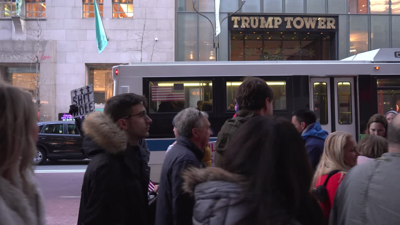 Two Protesters Outside of Trump Tower in Manhattan, People Walking By During Christmas Holiday Time