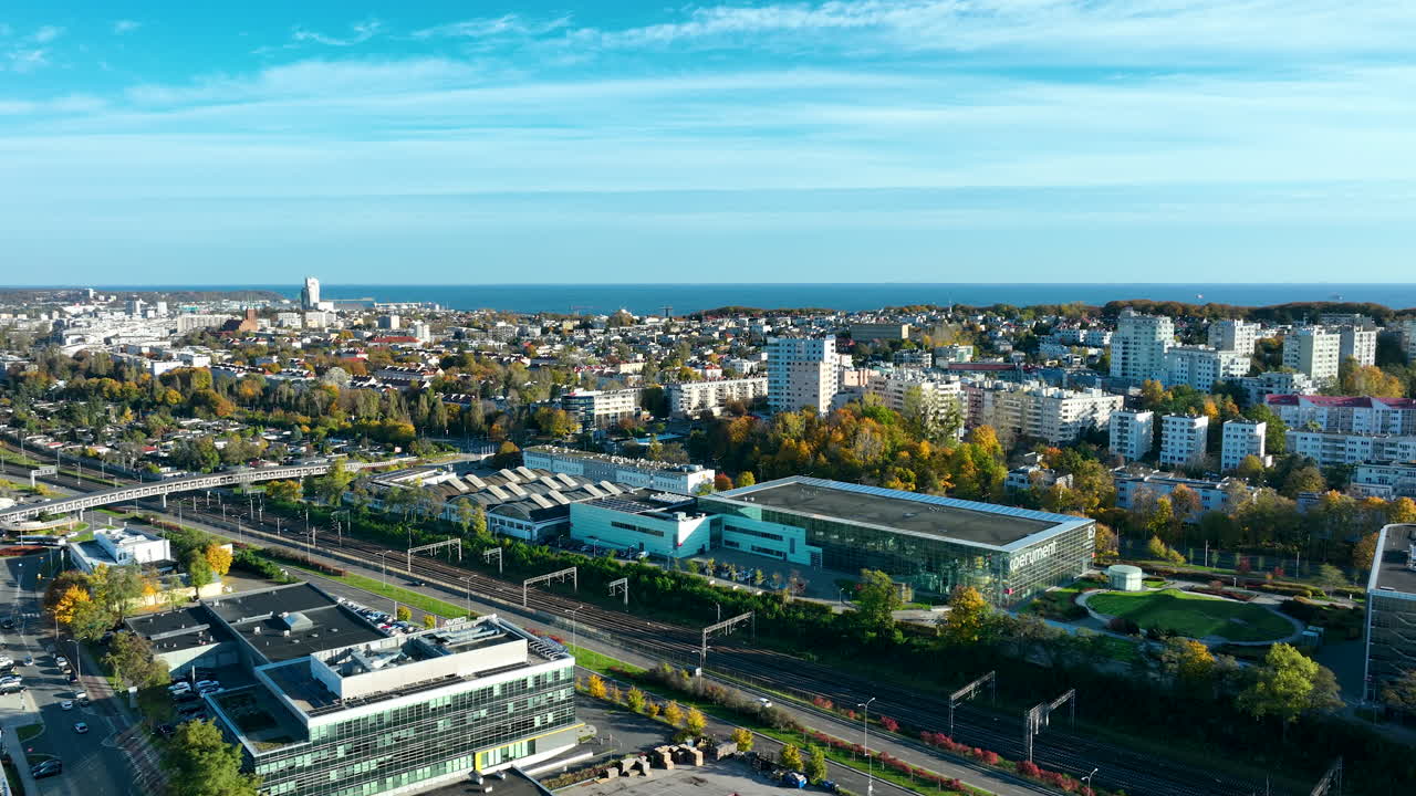 Aerial cityscape of Gdynia with sea coastline, modern residential buildings, and transport network in autumn light