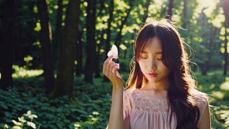 sunlight filters through trees illuminating a young woman in a long dress, holding a white butterfly on her finger in a serene forest setting