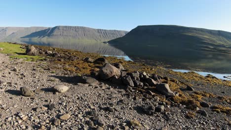 Paisaje-De-Los-Fiordos-Del-Oeste-Con-Una-Chica-En-Piedra-Y-Un-Lago-Tranquilo