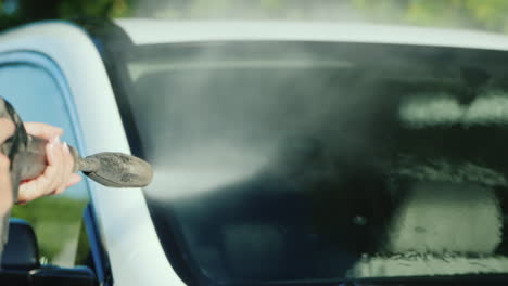 wash off dirt from a car windshield with a high pressure washer