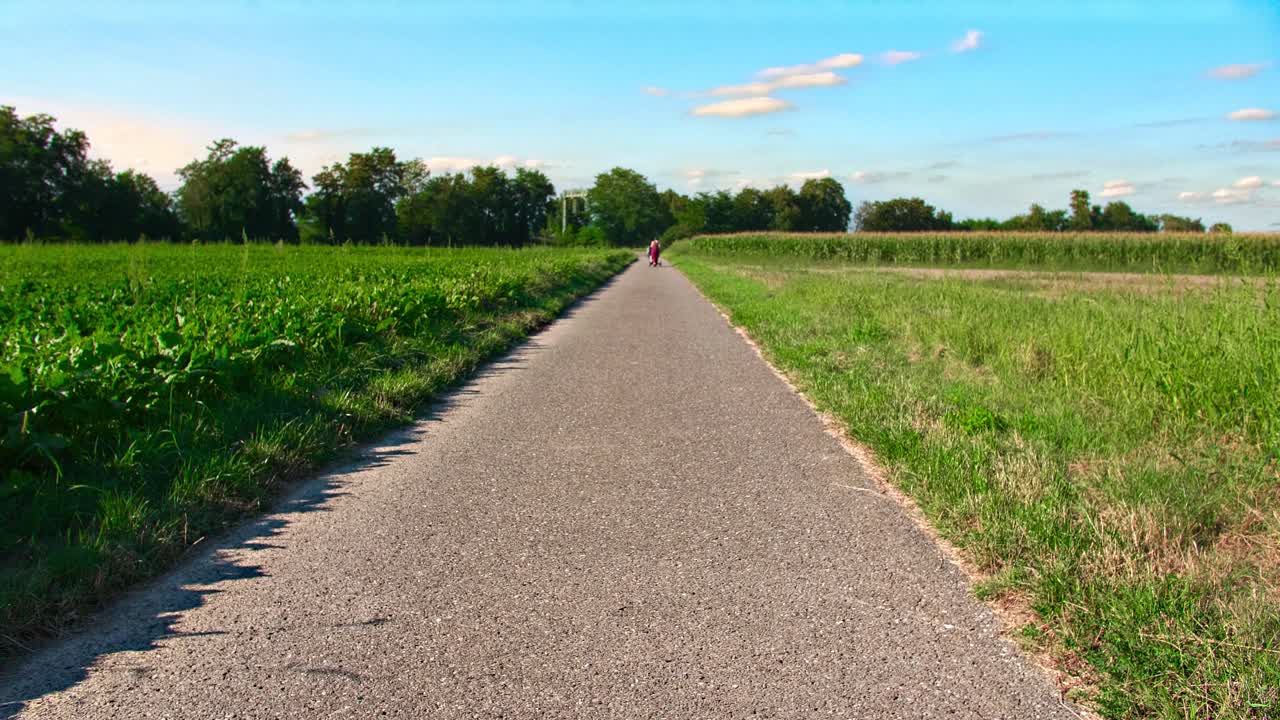 Open Farmland Under Blue Summer Sky; Woman Walking a Stroller in Distance