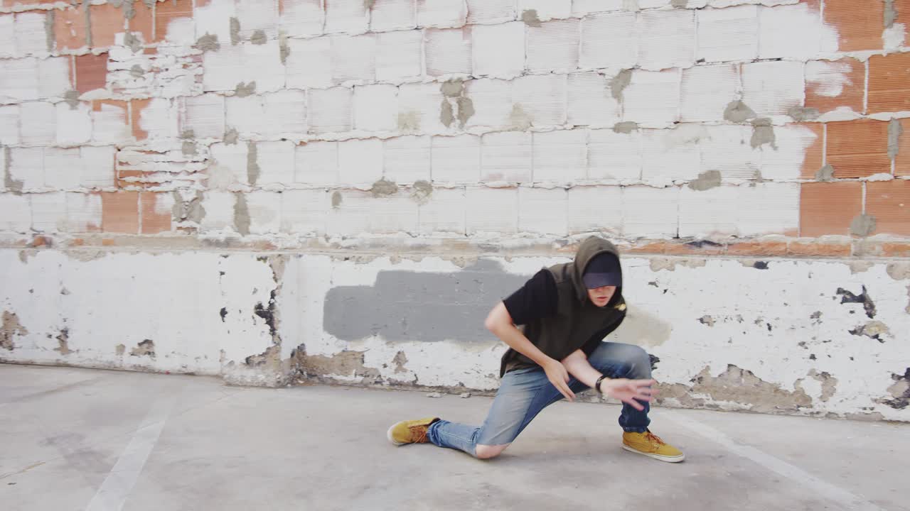 벽돌 벽 앞에 도시 밖에서 합 춤을 추는 남자