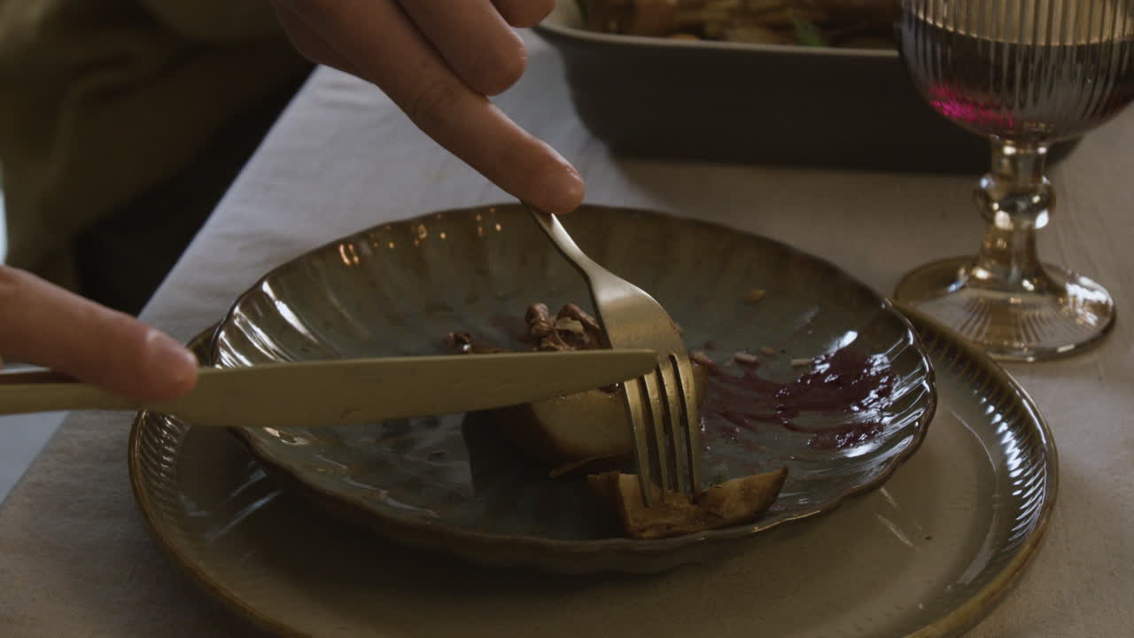 Close-up of person cutting dessert on plate