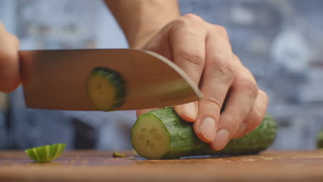 Cut a knife on a wooden board closeup cucumbers in the kitchen. shred